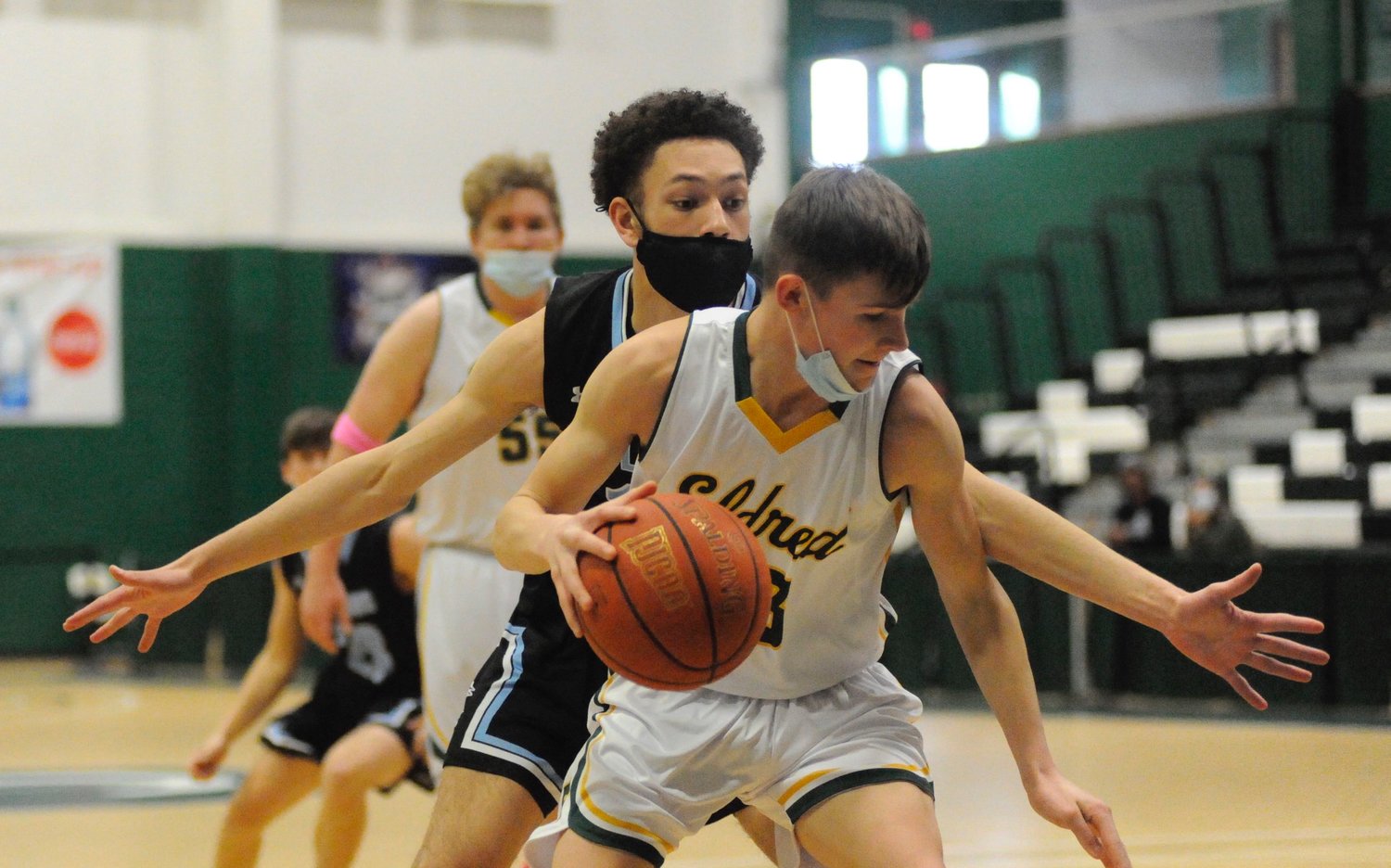 Don’t look back, something may be gaining on you. Eldred’s Sean Furler holds off Sullivan West’s Oscar DeChalus on defense.